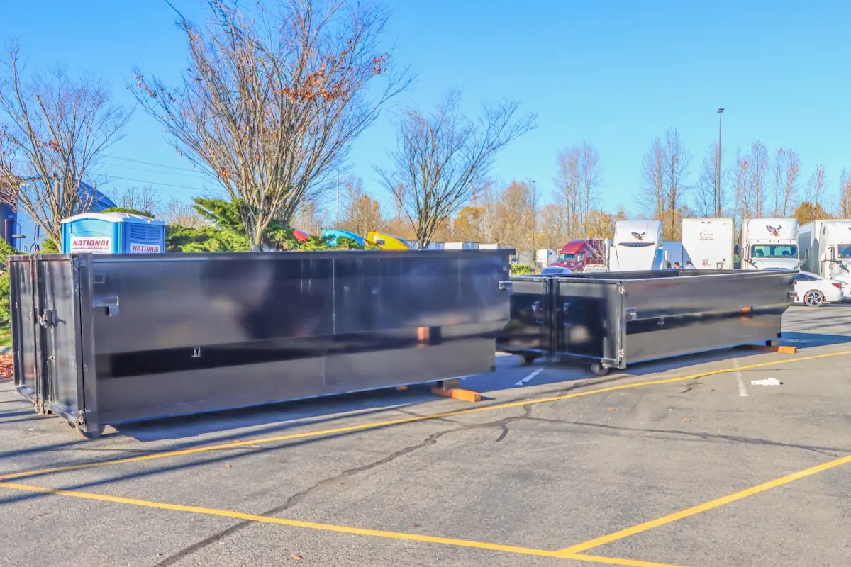 Professional dumpster rental service with roll-off container on residential driveway in Flint